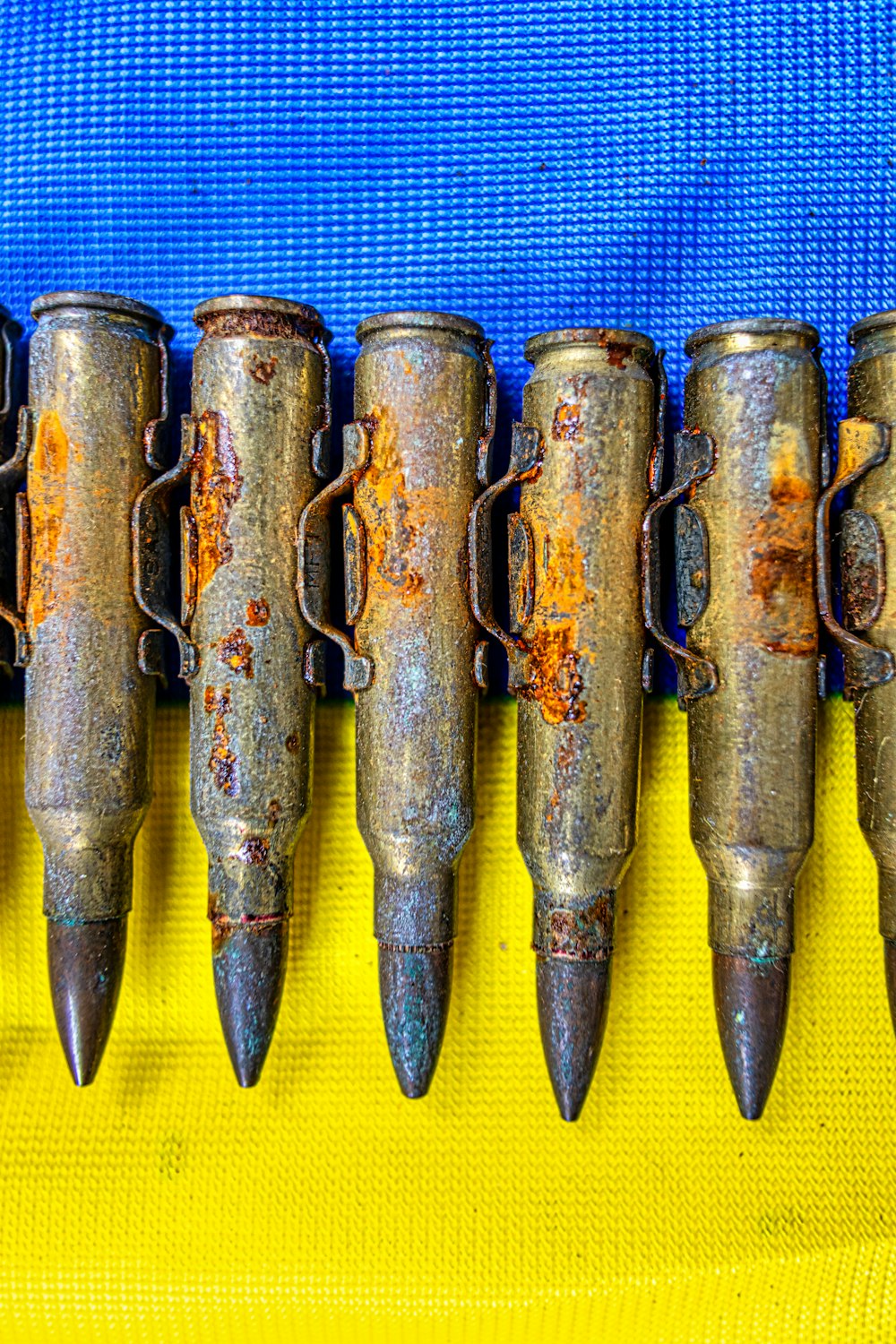 a row of rusty metal objects sitting on top of a blue cloth