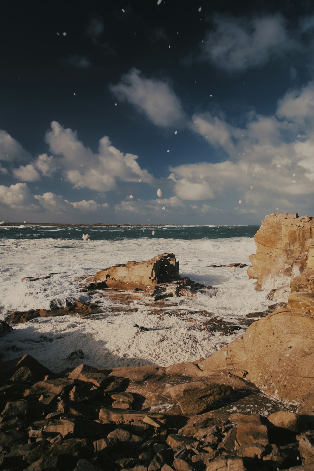 a rocky shore with waves crashing against the rocks