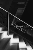 Black and white photo of a staircase with geometric lines and shadow play.