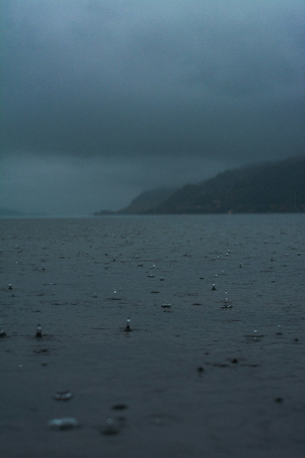 a body of water with a hill in the background