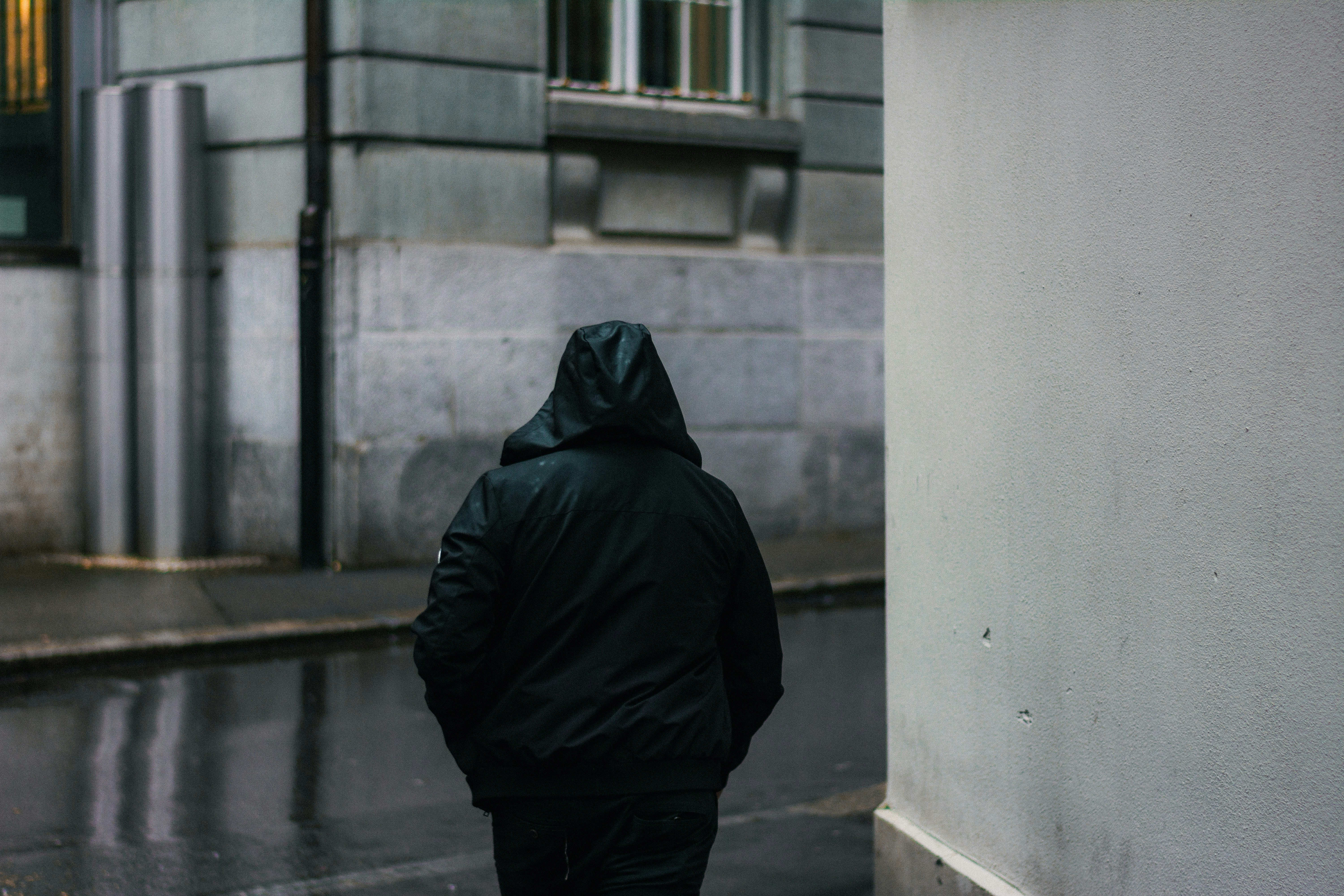 a person walking down a street in the rain