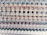 A close-up view of multiple spiral-bound notebooks stacked together, emphasizing the intertwined spiral bindings.