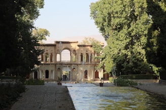 A historical park entrance showing traditional architecture surrounded by lush greenery.