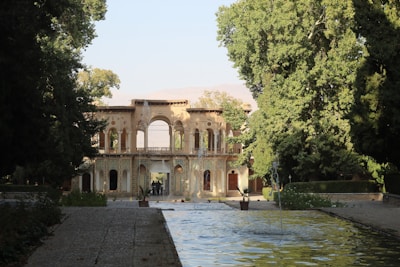 A historical park entrance showing traditional architecture surrounded by lush greenery.