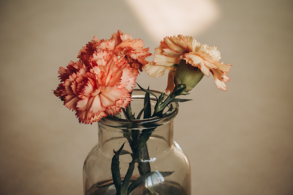 a glass vase filled with flowers on top of a table