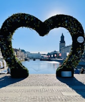 Sunlight filtering through a floral heart arch, casting gentle shadows on the beach.