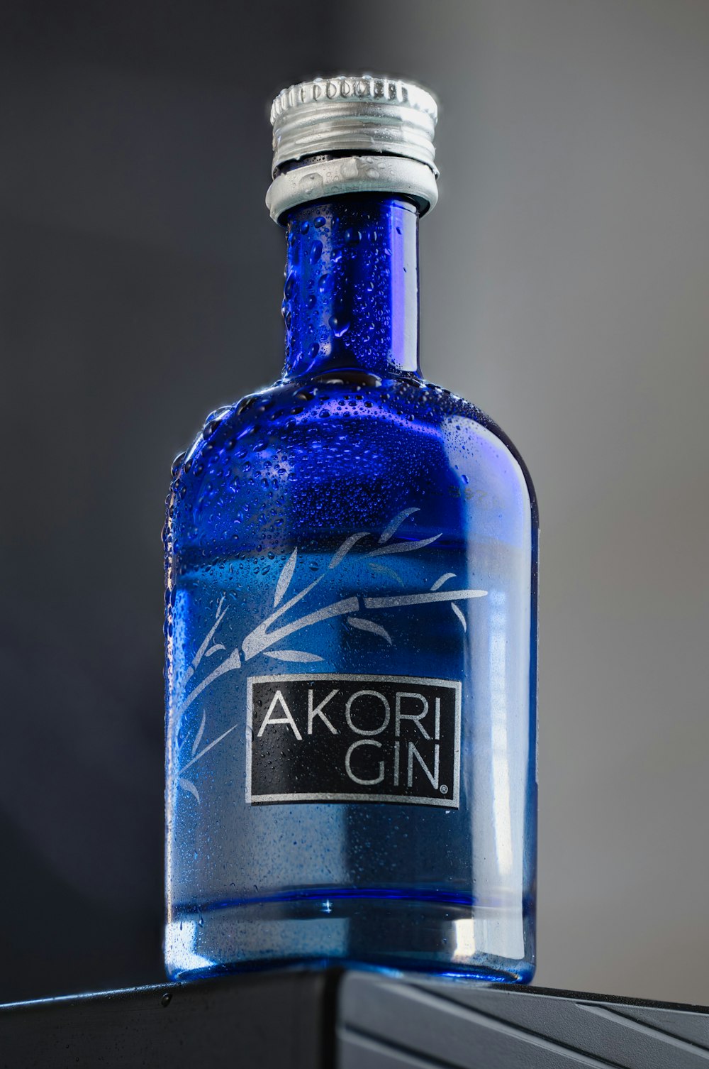 eine blaue Flasche Alkohol, die auf einem Tisch steht