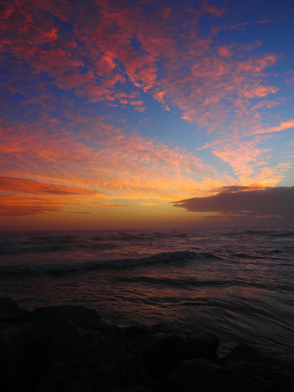 a sunset over a body of water with waves