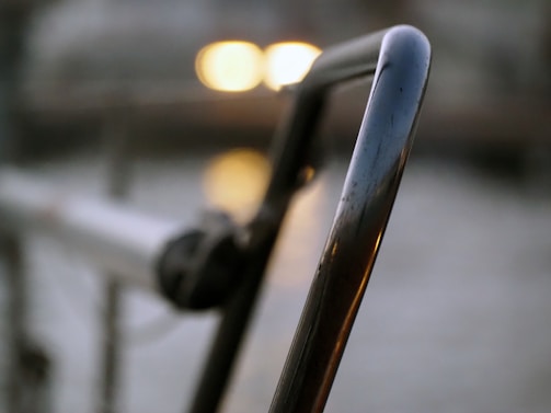 Close-up of sleek aluminum glass railing with sunlight reflecting gently off the smooth metal surface.
