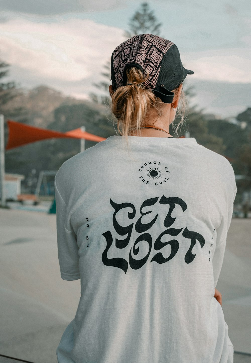 a woman wearing a white shirt with black writing on it