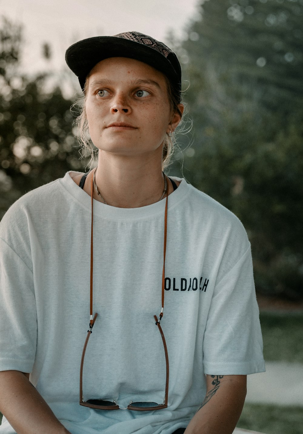 a woman sitting on a bench wearing a hat