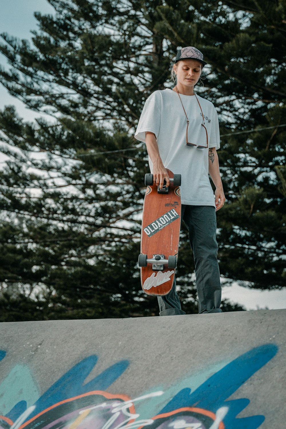 a young man holding a skateboard on top of a ramp