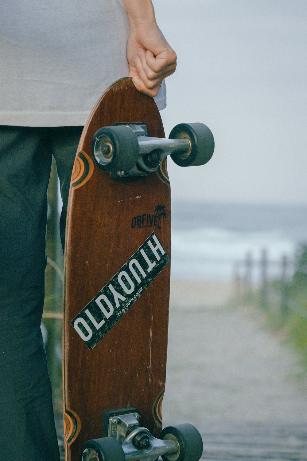 a person holding a skateboard on a path