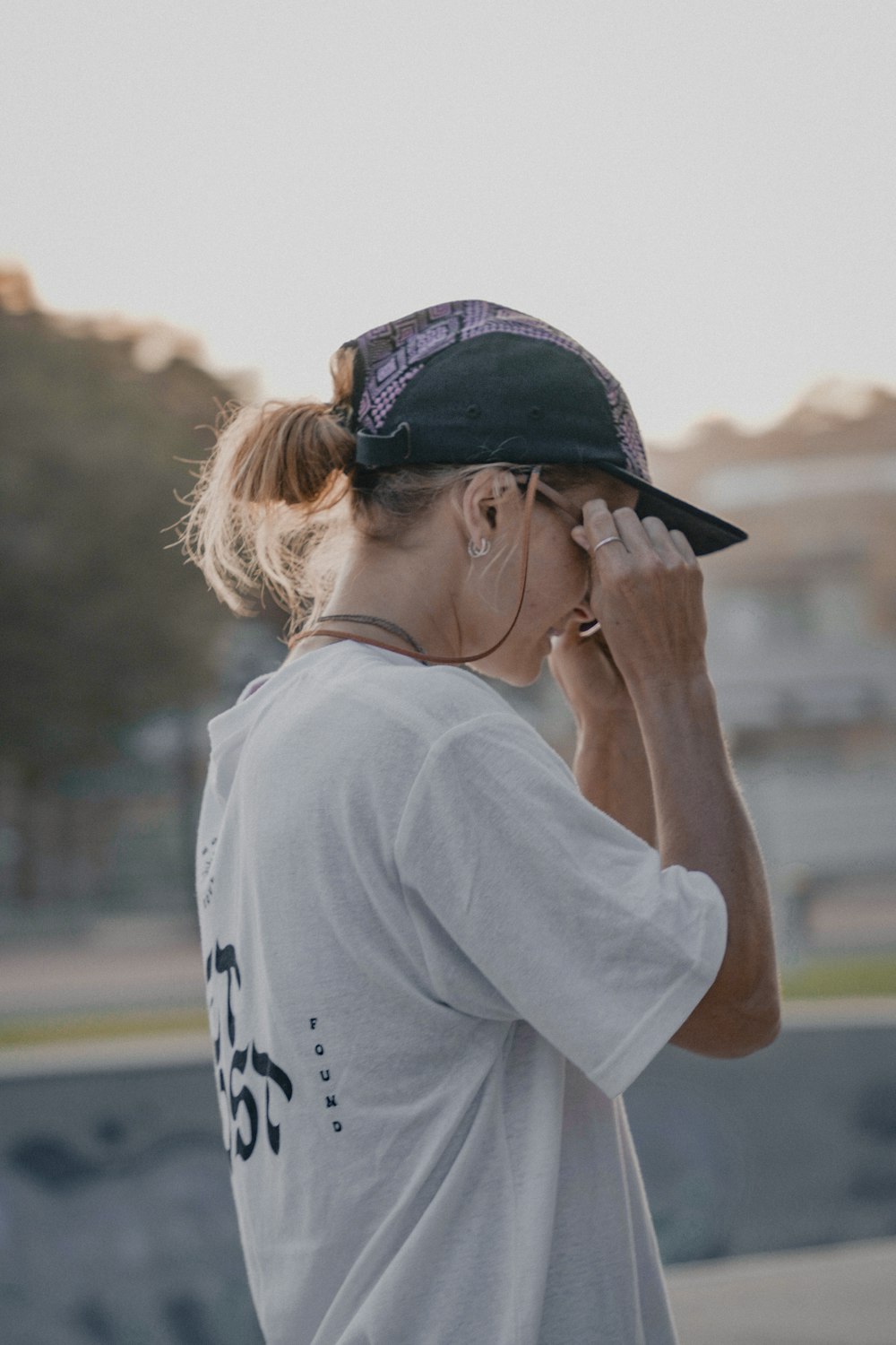 a woman wearing a hat is talking on her cell phone