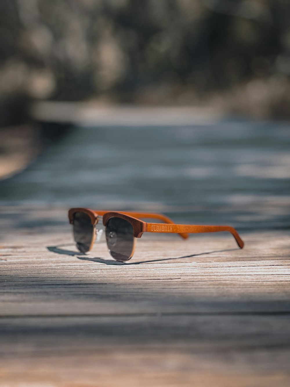 a pair of sunglasses sitting on top of a wooden table