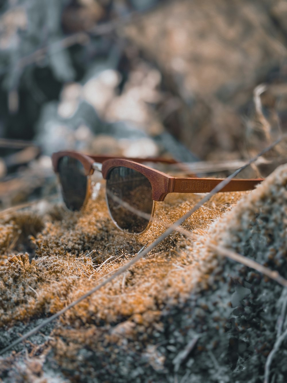 a pair of sunglasses sitting on top of a rock