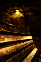 Side view of a glowing cap casting colorful light on a wooden bench.