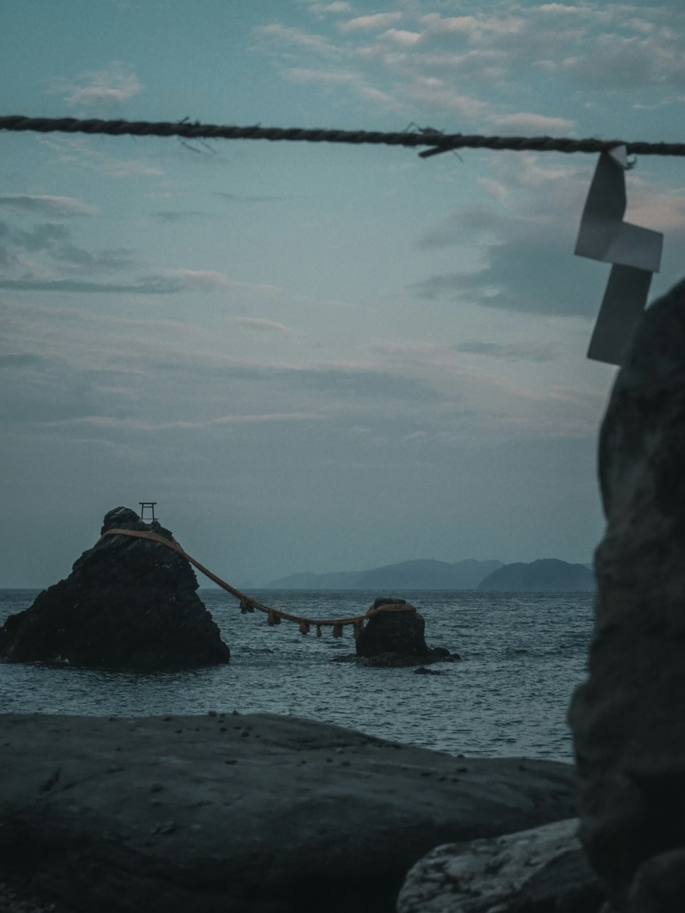 a boat tied to a rock in the ocean