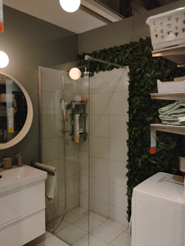 A bright, modern walk-in shower with glass enclosure and minimalist fixtures.