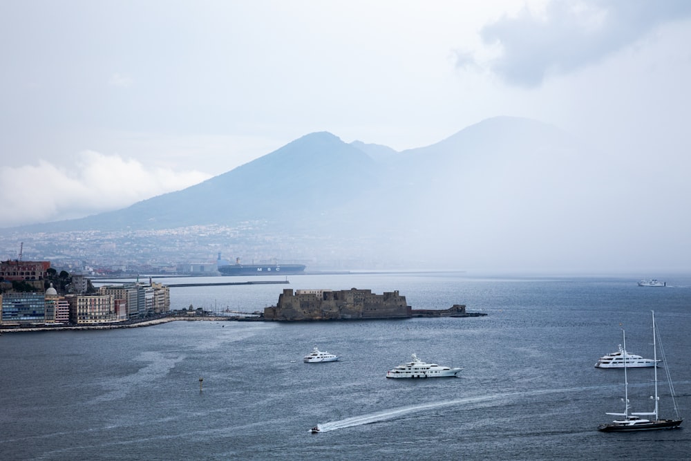 a body of water with boats in it and a mountain in the background