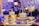 Ornate glass and gold decorative items are arranged on a tray, surrounded by crystal chandeliers and a warm ambient glow. The luxurious design features intricate details and craftsmanship.