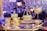 Ornate glass and gold decorative items are arranged on a tray, surrounded by crystal chandeliers and a warm ambient glow. The luxurious design features intricate details and craftsmanship.