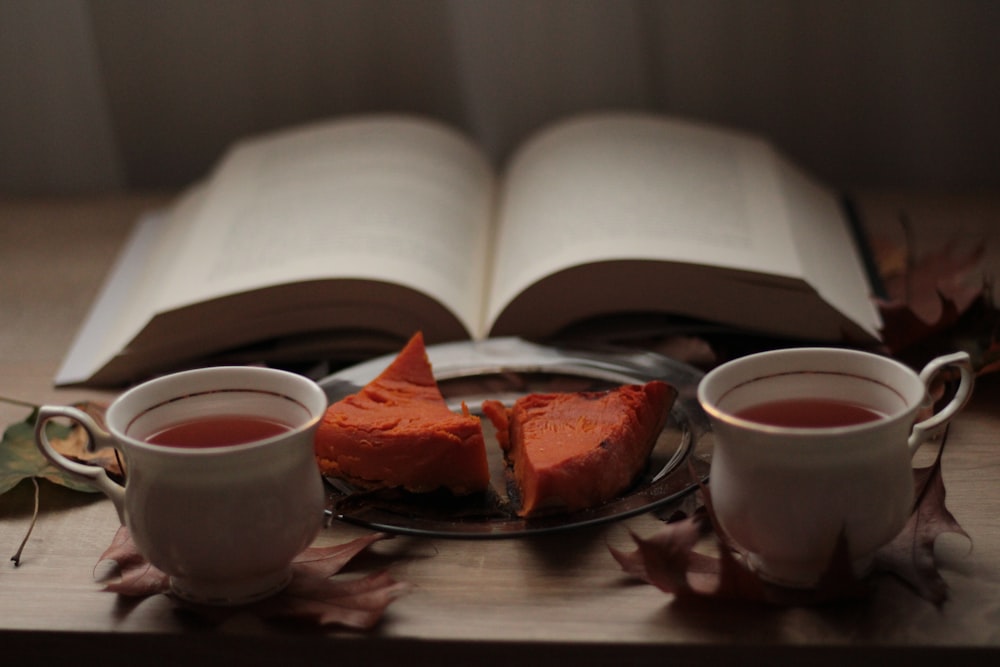 two cups of tea and a book on a table