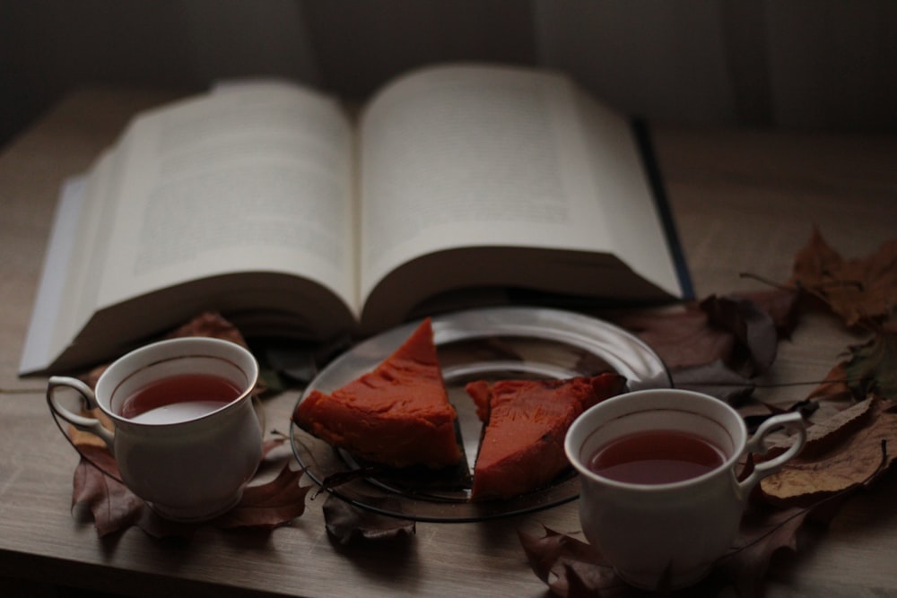 two cups of tea and a book on a table