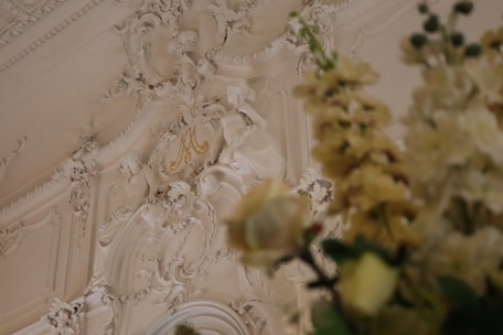 Close-up of intricate plaster molding featuring floral motifs typical of 18th-century French interiors.