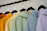 A cozy, colorful hoodie with artistic prints displayed on a wooden hanger.