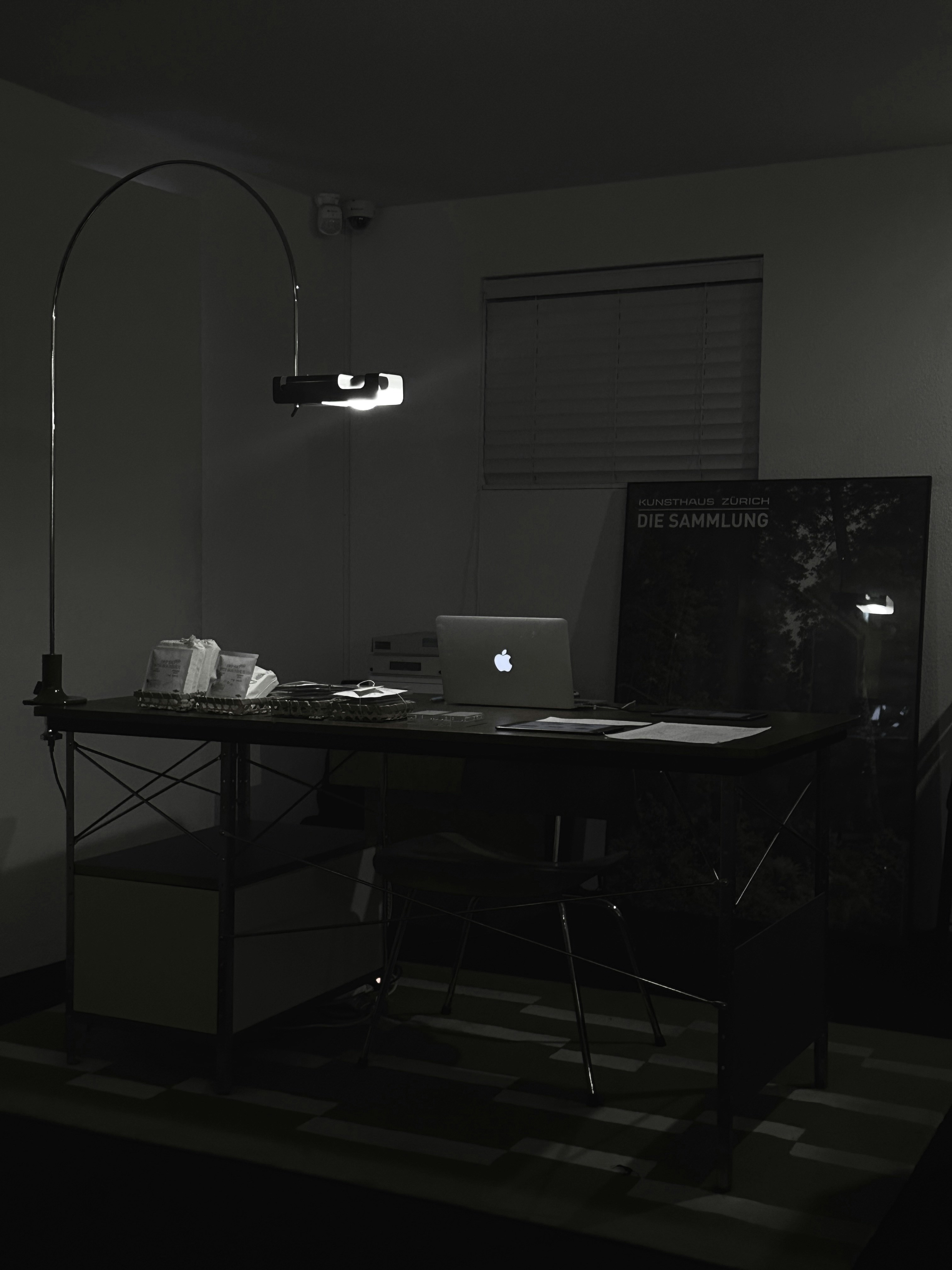 Laptop computer on dark desk with dramatic side lighting, professional business equipment