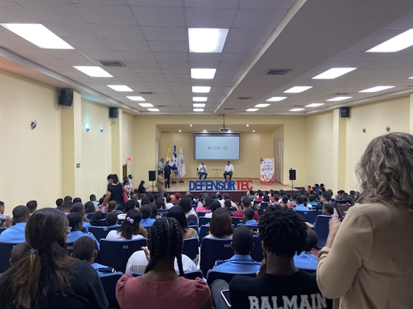 Geovanny A. Barrantes delivering a keynote speech on stage with an attentive audience.