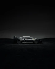 A sleek noirveloce car silhouette illuminated by cinematic lighting against a dark, minimalist backdrop.