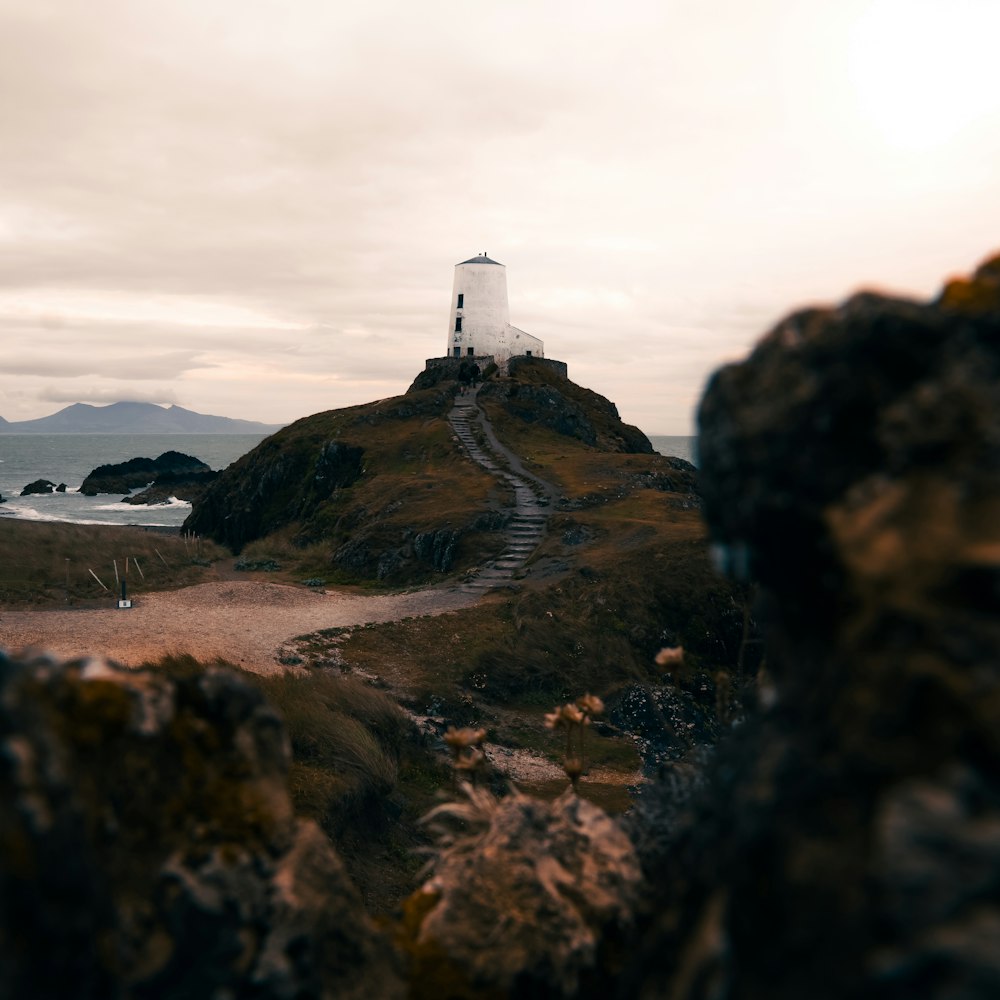 a lighthouse on top of a hill near a body of water