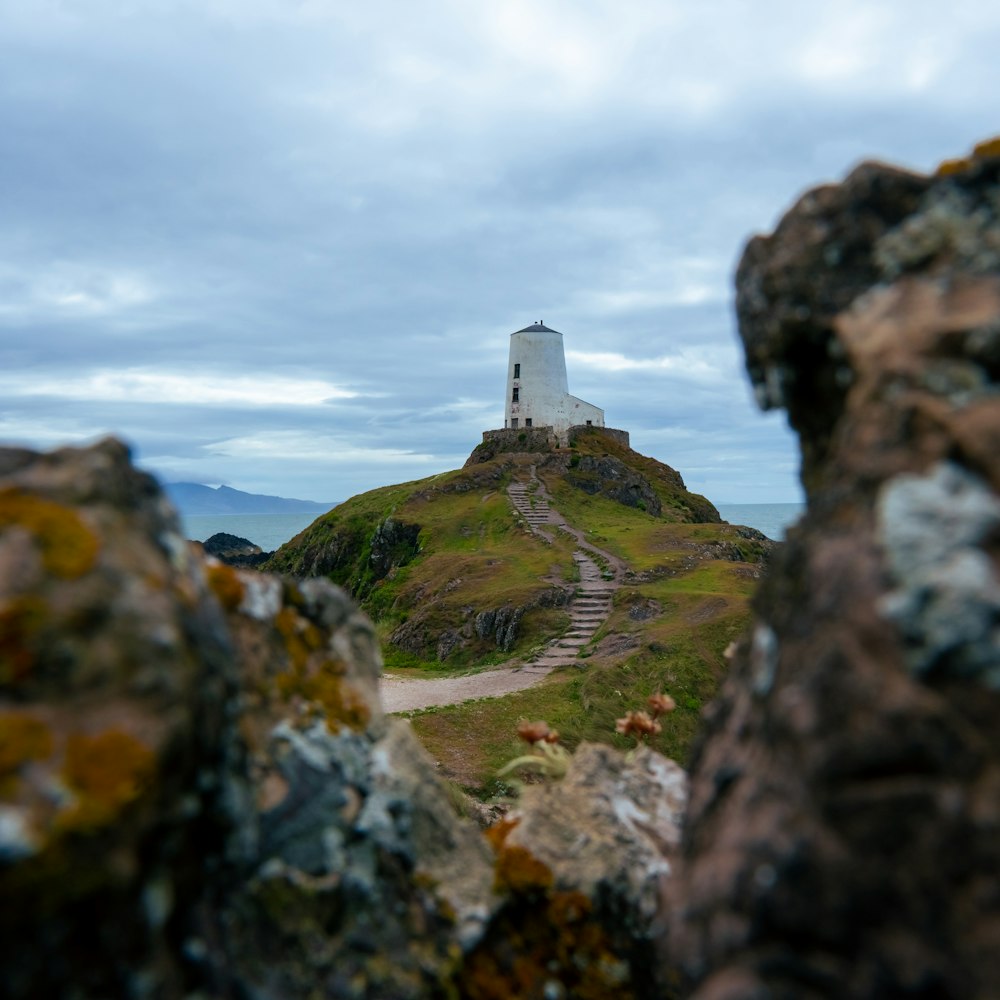 a lighthouse on top of a grassy hill