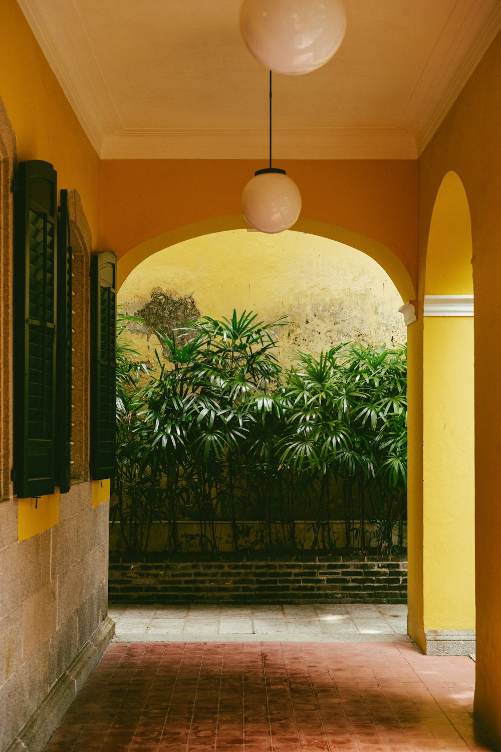a hallway with a yellow wall and a painting on the wall