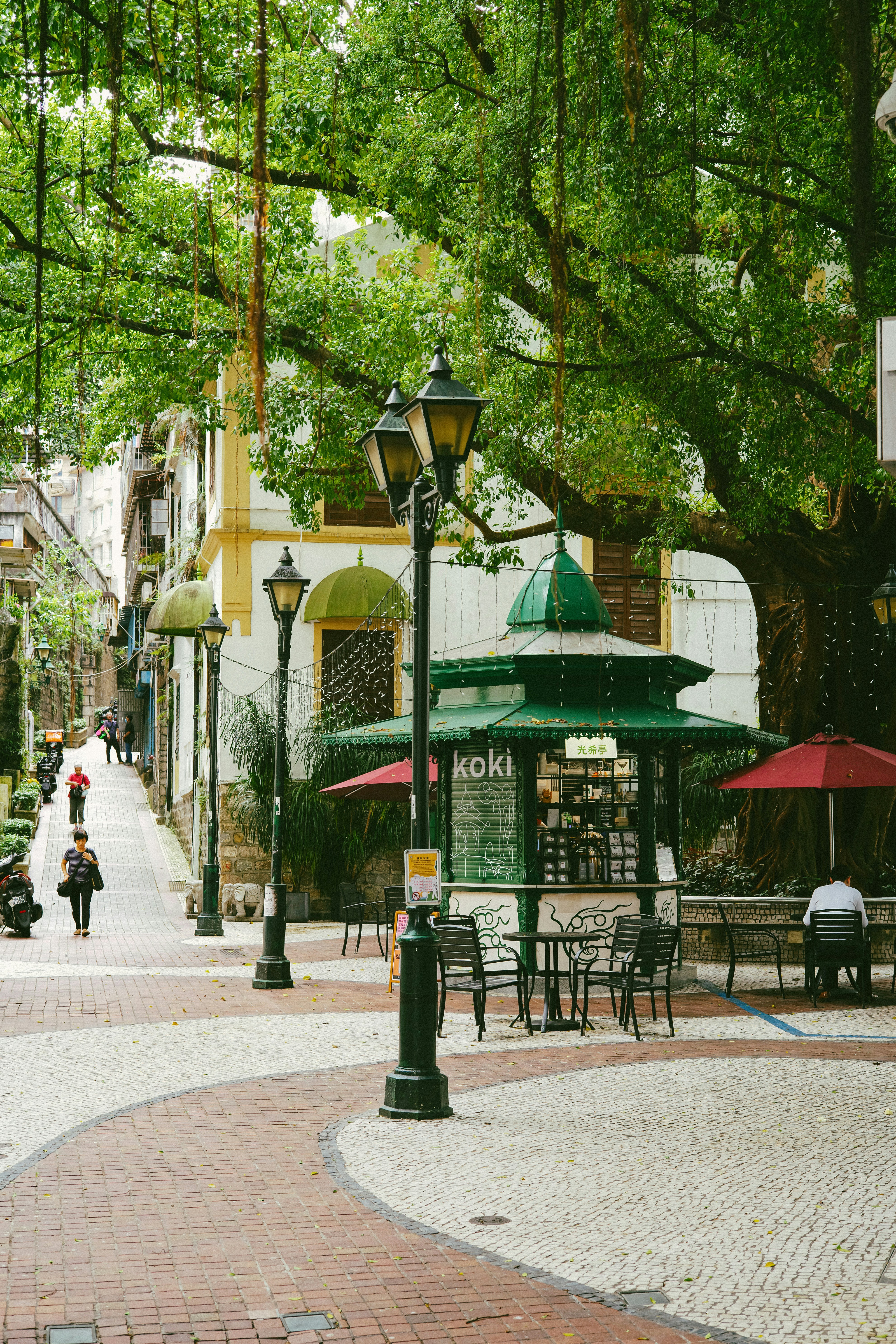 a couple of people sitting at a table under umbrellas