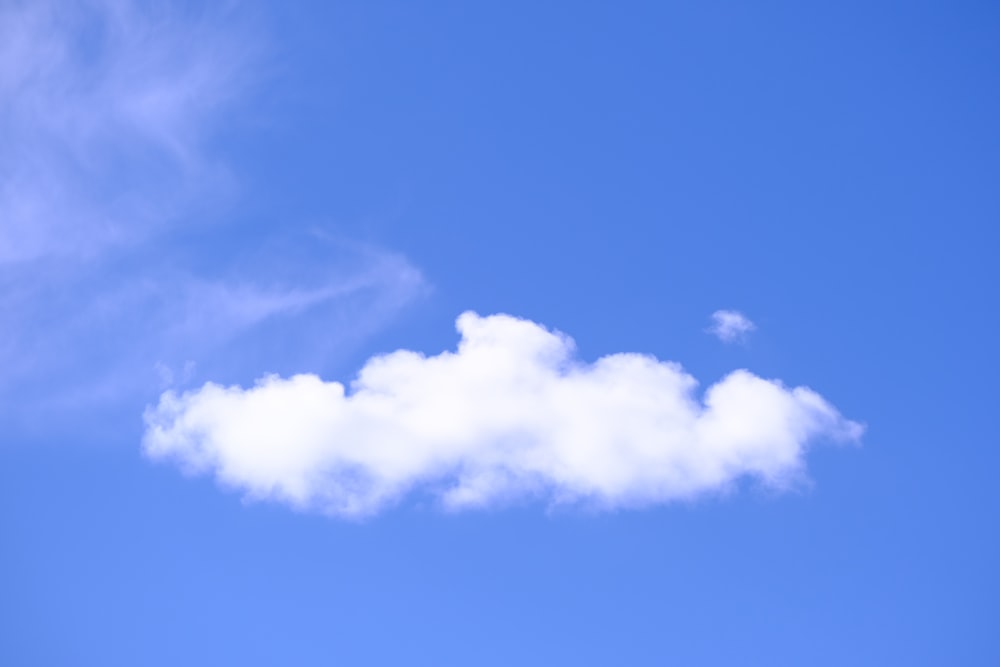 uma nuvem branca flutuando em um céu azul