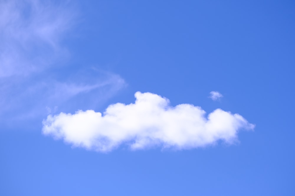 a white cloud floating in a blue sky