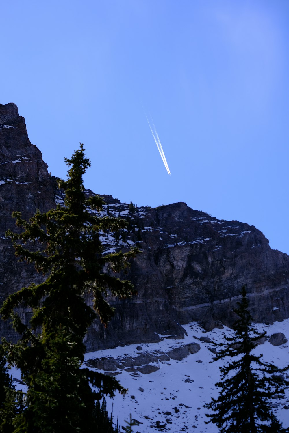 a plane is flying over a snowy mountain