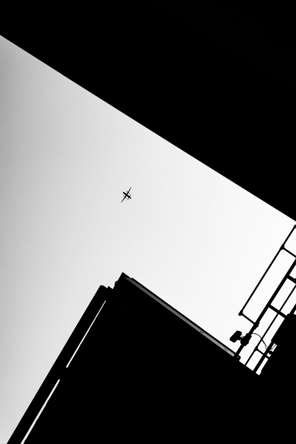 ein Schwarz-Weiß-Foto eines Flugzeugs, das am Himmel fliegt