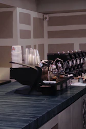 Modern espresso and latte cups on a sleek black countertop with soft glowing light.