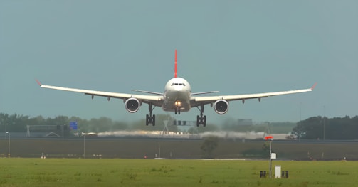 A tailwheel aircraft performing a smooth landing on a grass strip.