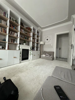 A cozy therapy room with soft lighting and a comfortable chair beside shelves filled with psychology books and calming plants.