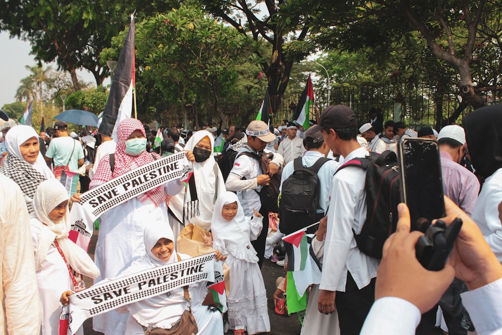 a group of people walking down a street holding signs