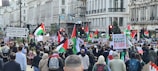 A vibrant street protest in an international city, people holding flags and banners.
