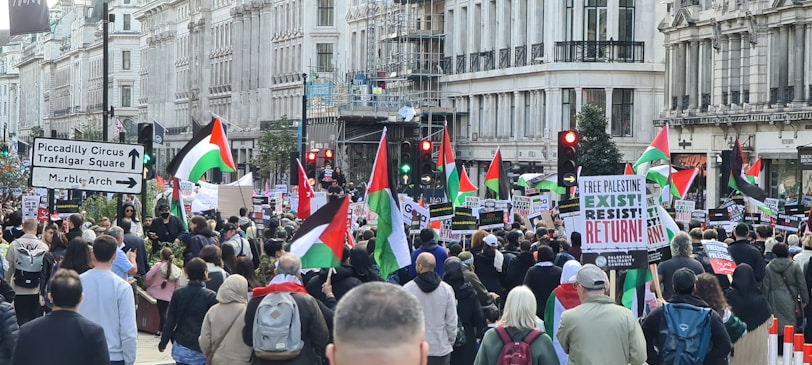 A vibrant street protest in an international city, people holding flags and banners.