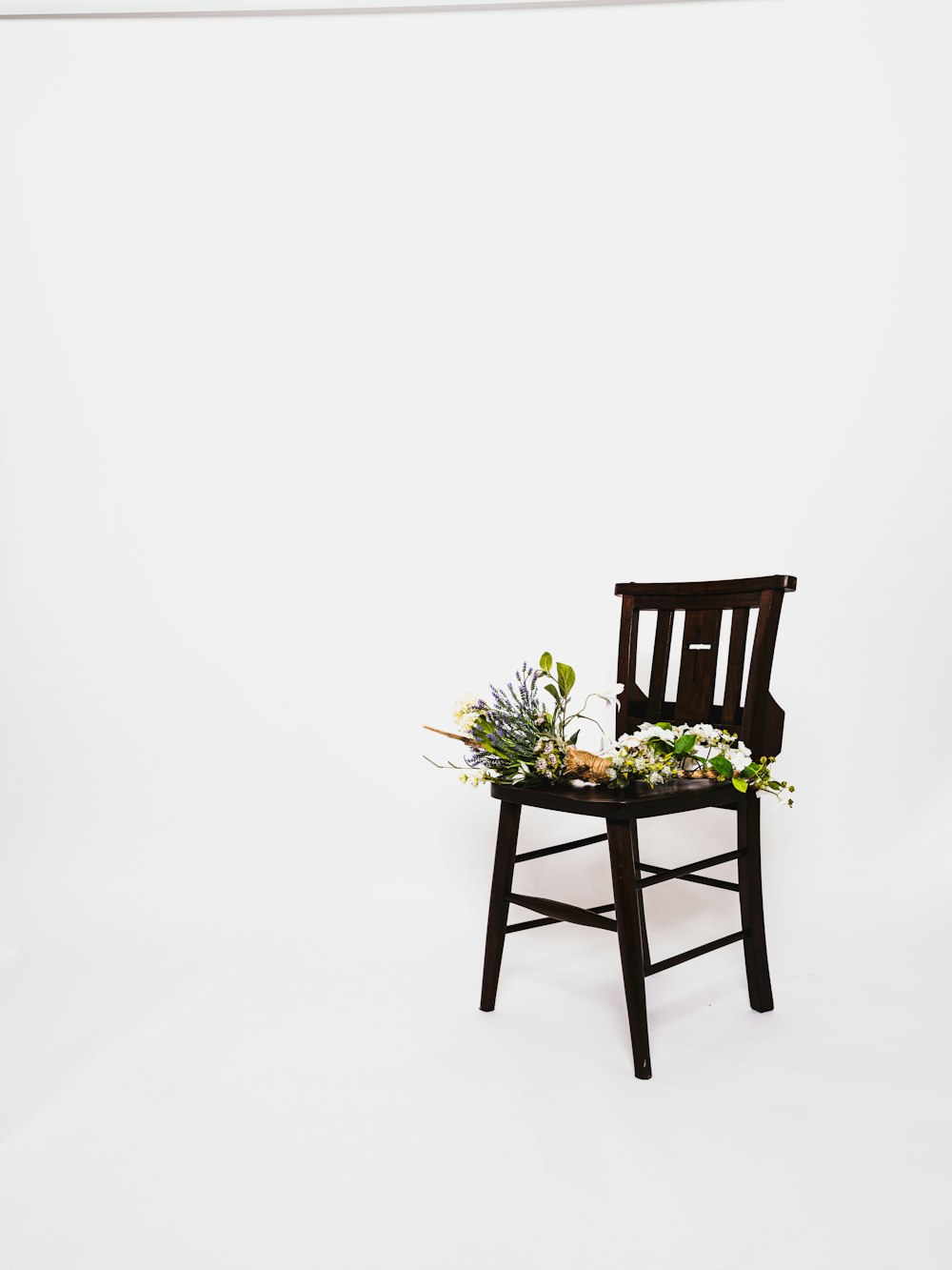 a wooden chair with a flower arrangement on it