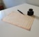 An elegant vintage document with a quill and inkpot on a wooden table.