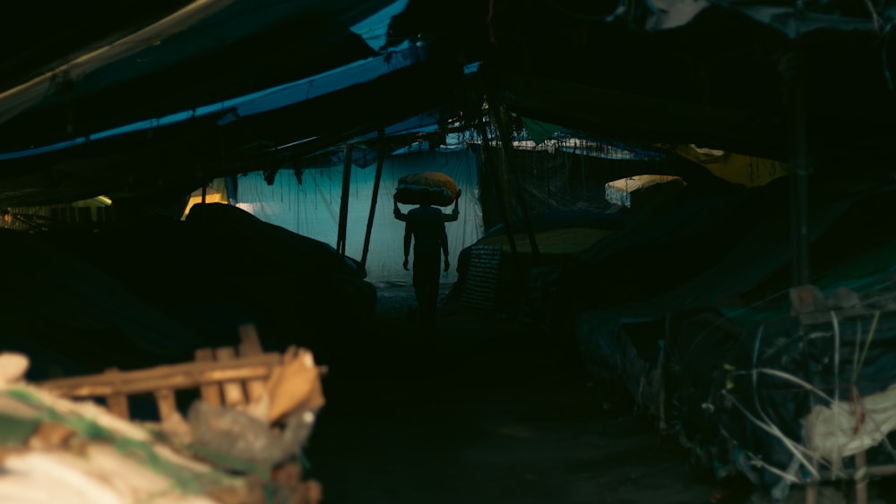 a man standing inside of a tent in the dark